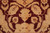 Macro of ivory and gold palmettes knotted against the deep burgundy medallion ground