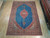 8'2" x 11'11" Persian Kashan rug displayed flat on light wood showroom floor