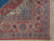 Corner detail showing madder red floral border, ivory reserves and dense hand-knotted wool pile