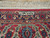 Close-up of woven signature cartouche in navy border above red guard stripe and ivory fringe