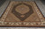 Angled floor view showing the fish pattern field, scalloped medallion and ivory border of this rug