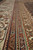 Detail of the ivory main border and multiple guard stripes in rust, green and blue