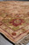 Perspective view along the border of the square 8 by 8.5 foot Indian wool rug with fringe