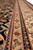 Low angle along the border stripes showing rosettes, teardrop motifs and black zigzag guard bands