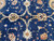 Center of field close-up with paired ivory rosettes and gold blossoms on midnight blue