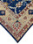 Angled corner detail showing navy diamond cartouches and rust cusped medallions in wide border