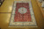 6' x 9' silk Oriental rug photographed flat, showing red field and full ivory border frame