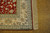 Corner detail of ivory main border, guard stripes, red selvage and hand-tied silk fringe