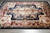 Angled view showing soft fold lines across the ivory medallion and burgundy floral border