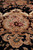 Secondary blush cartouche with roses, palmettes and brown acanthus leaves on the black ground