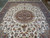 Wide view of the ivory Tabriz rug showing balanced medallion, spandrels and navy outer border