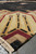 Low angle view of the shield shaped corner panel in gold, burgundy and black wool