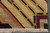 Corner detail with diagonal gold rays, black dashes and burgundy outline above the ivory fringe