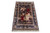 Angled display of hand-knotted silk pictorial rug showing navy border, ivory guard bands and figural scene