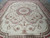 Full length view of 9x12 needlepoint rug with symmetrical scrollwork and rose corner bouquets
