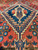 Low angle showing thick hand-knotted wool pile and crisp ivory zigzag outlines around the medallion