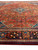 Rust field with all-over floral lattice meeting brown border with orange and red panel motifs