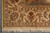 Corner of the beige rug showing outer guard stripe, main border pattern and hand-tied fringe