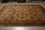 Hand-knotted wool rug on showroom floor showing all over palmette pattern and wide brown border