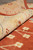 Rolled edge showing medium pile depth, beige border and rust ground with cream blossoms