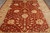 Overhead detail of coral rust field with sage green leaf sprays and gold palmette blossoms