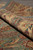 Rolled edge showing thick fine wool pile, soft green selvage and floral border colors