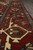 Border detail with turquoise vine, ivory rosettes and brown lozenge cartouches on rust red ground