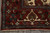 Corner view of 10x14 Oriental rug with teal border, ivory cartouche and hand-tied fringe