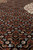 Macro of the black field showing tiny fish motifs in rust, ivory and silver grey