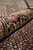 Rolled edge showing thick wool pile, silk sheen and floral main border on black ground