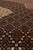 Angled pile close-up showing tiny fish herati diamonds in rust, olive and ivory wool