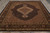Hand-knotted 8x10 Oriental rug photographed lengthwise showing camel spandrels, scalloped medallion and ivory fringe