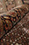 Rolled edge photograph highlighting soft wool and silk pile and multicolor floral border on black