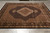 Black and camel wool and silk area rug displayed at an angle on grey tile