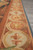 Edge detail showing rosette and fleur-de-lis medallion border with blue selvedge on grey floor