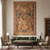 Wall-hung 6' x 9' tapestry above a green sofa in a neutral library-style living room