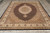 7'11" x 10'2" hand-knotted rug photographed on grey plank floor with cotton fringe showing