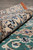 Rolled edge of the rug beside the green field, showing plush pile height and ivory border