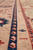 Macro of navy guard stripe with peach motifs beside a fine red vine minor border