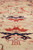 Close-up of the pale field showing red and navy palmettes with a peach cloudband shield