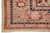 Corner close-up of dusty rose main border with red rosettes and indigo chain guard stripe