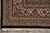 Corner view of black outer border, layered guard stripes and clean ivory fringe