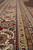 Multi-band border detail with palmettes, rosettes and vine scrolls in ivory, red and olive