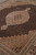 Detail of lobed ivory medallion, pendant and rust outline against densely knotted black ground