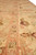 Low angle along the border showing coral stripes, brown leaf motifs and fine knot definition