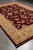 Perspective view of the large burgundy area rug on grey floor, ideal for living rooms