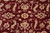 Detail of ivory and olive green rosette motif knotted on burgundy handspun wool pile