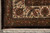 Corner close-up of ivory border palmettes, olive guard band and plush dark brown outer edge