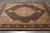 Black and beige wool and silk rug photographed on grey tile floor showing full Herati field