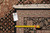 Back tag and tape measure confirming size and hand-woven construction of this wool and silk rug